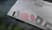 White shirt with red and black in transparent paper packaging.